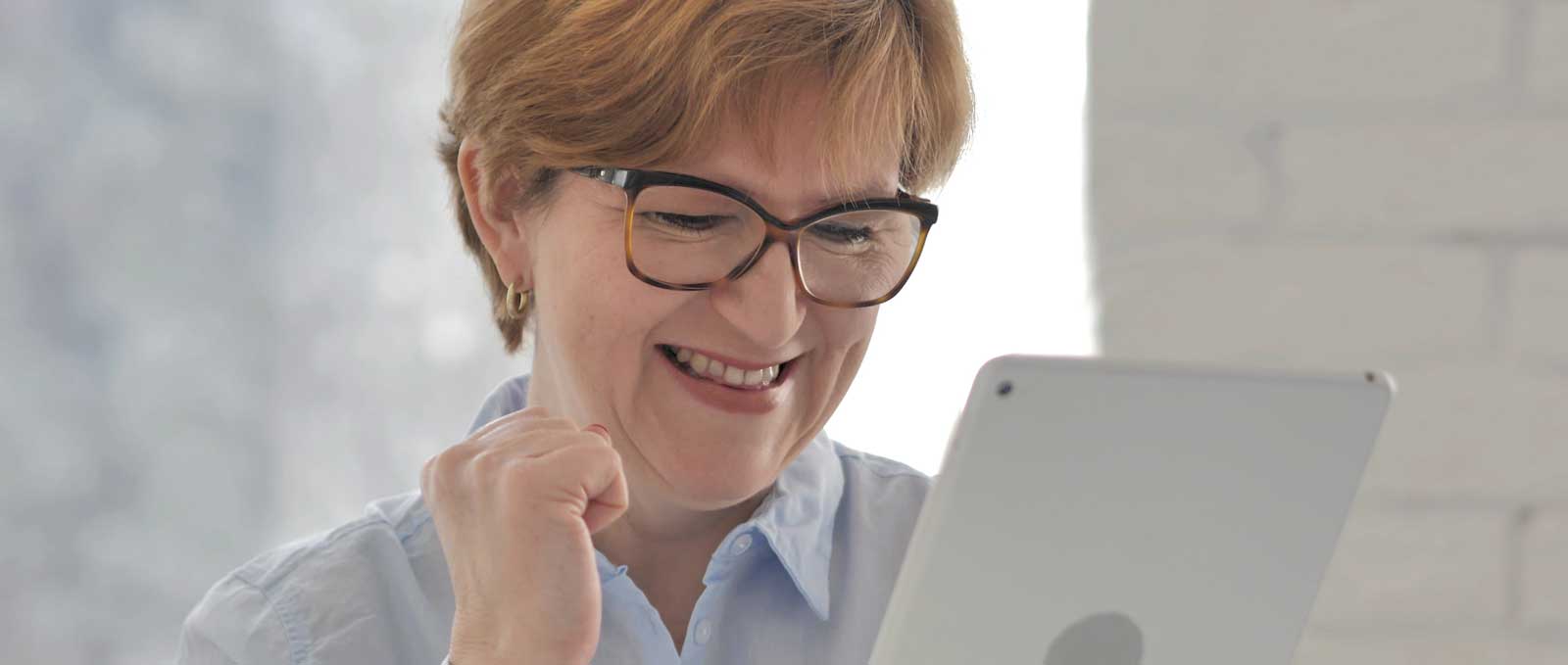 Middle-aged woman reading engaging marketing content on her tablet